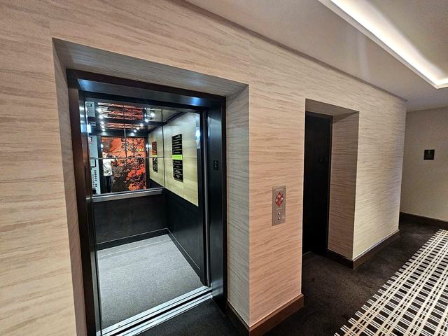 Travertine-look corridors — hotel: Elevator landing