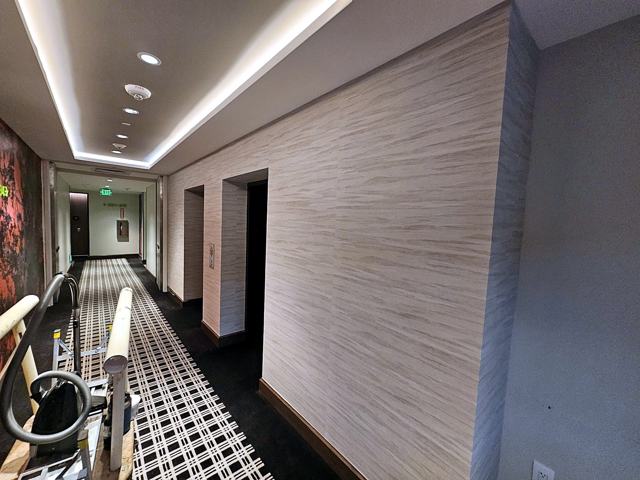 Travertine-look corridors — hotel: Cove-lit corridor