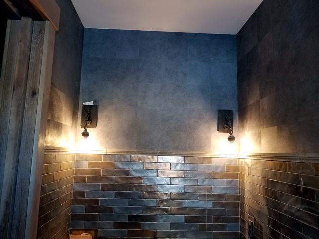 Stone-effect bath with metallic tile: Finished with sconces