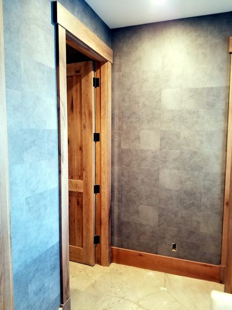 Stone-effect bath with metallic tile: Paper and wood door